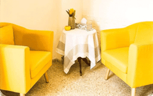 כורסאות צהובות ובניהן שולחן קטן